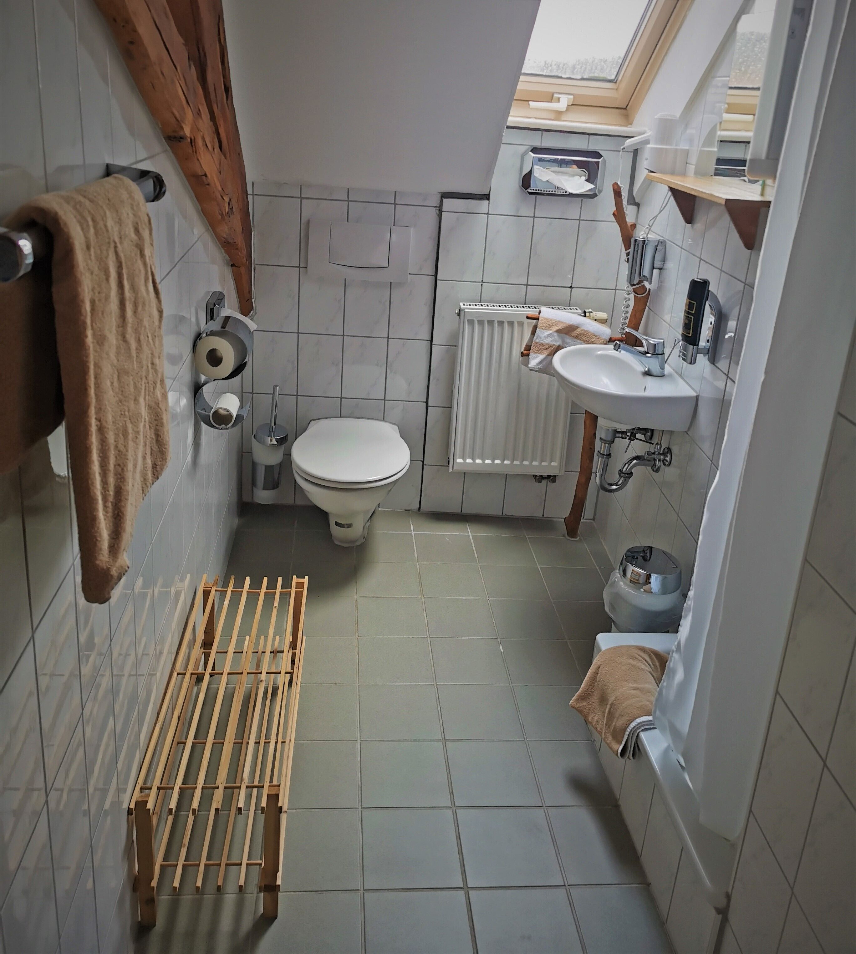 A compact bathroom with a toilet, sink, and shower area.