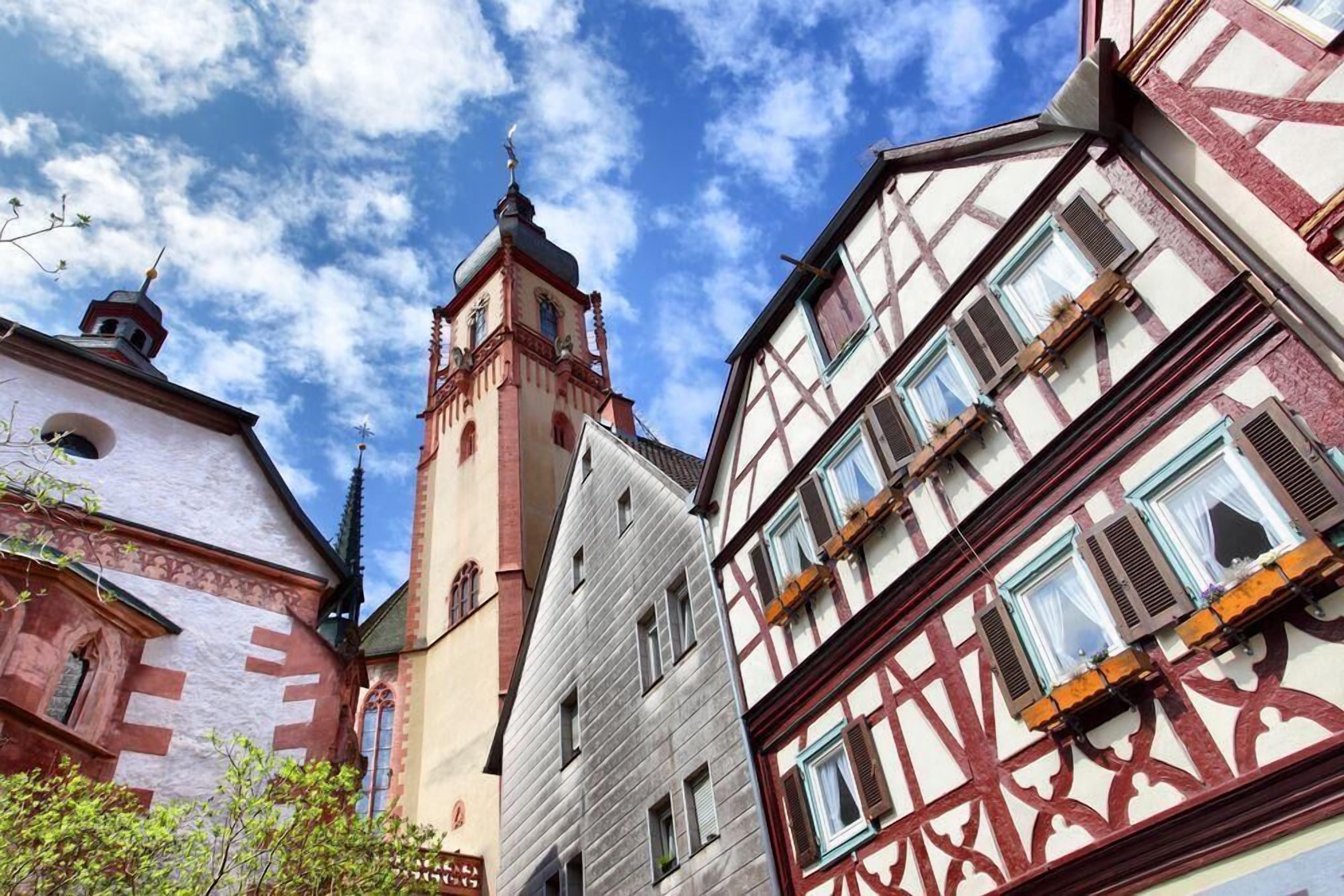 A street view with traditional half-timbered buildings and a church tower.