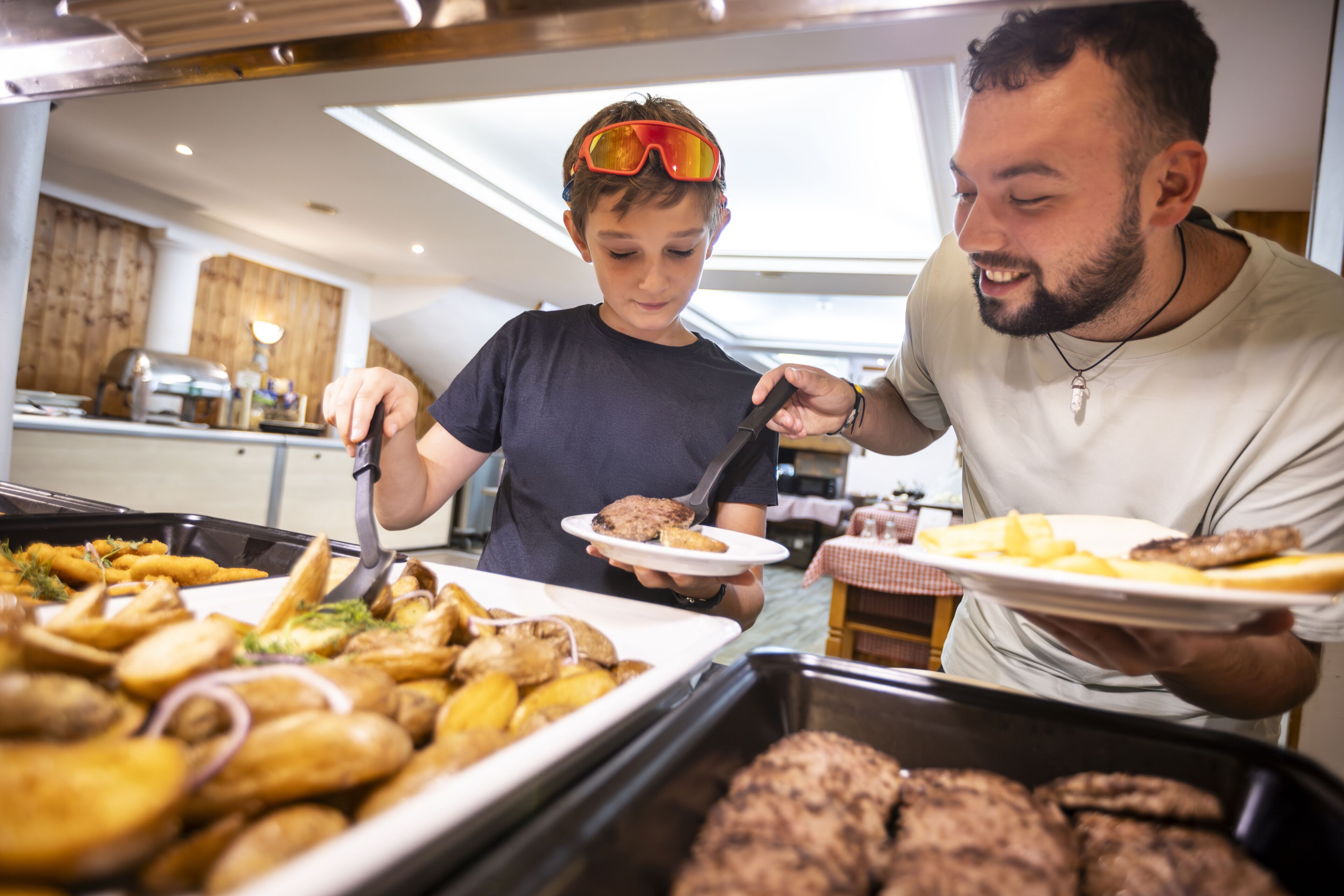 A buffet with various food items including meats, potatoes, and vegetables.