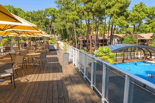 A wooden deck with outdoor seating and a pool area.