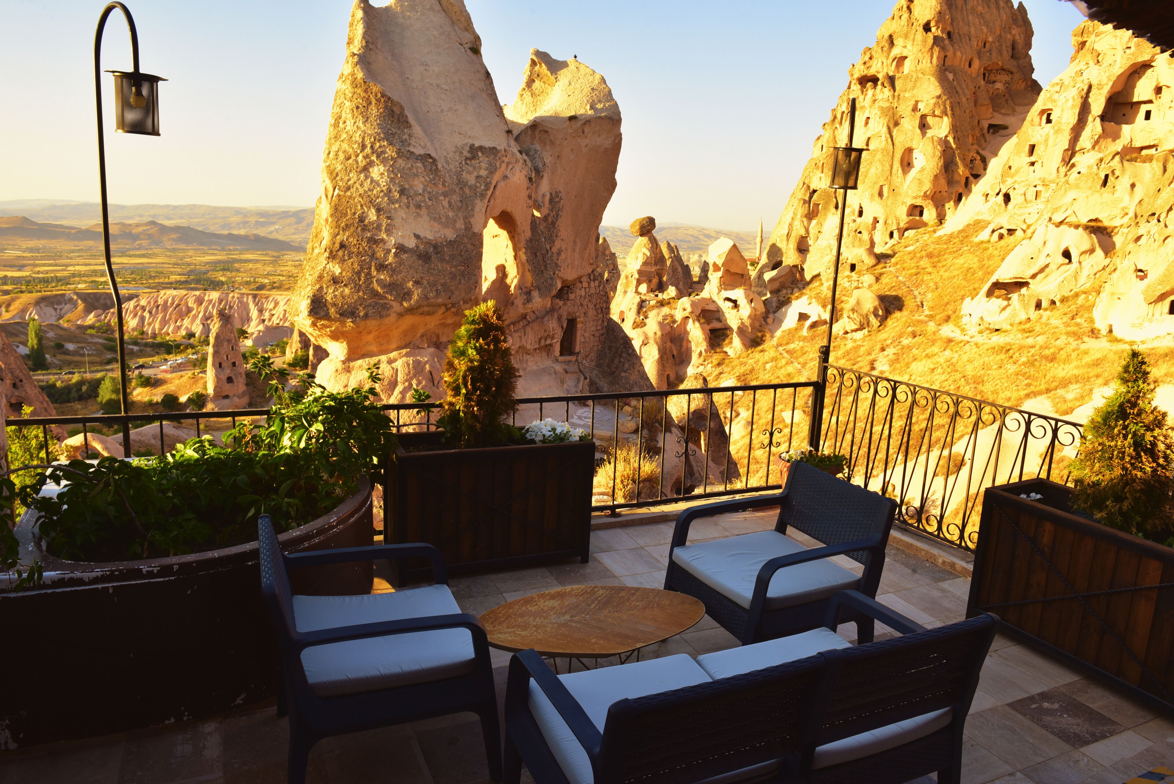 A terrace with outdoor seating, a lamp, and a view of rock formations.