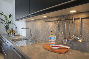 Apartamento luxo | Cozinha privada | Talheres/pratos/utensílios de cozinha, produtos de limpeza, freezer