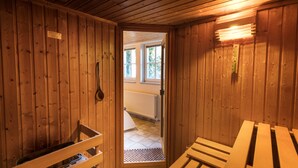 Un sauna de madera con bancos y un banco que tiene un perchero para toallas.