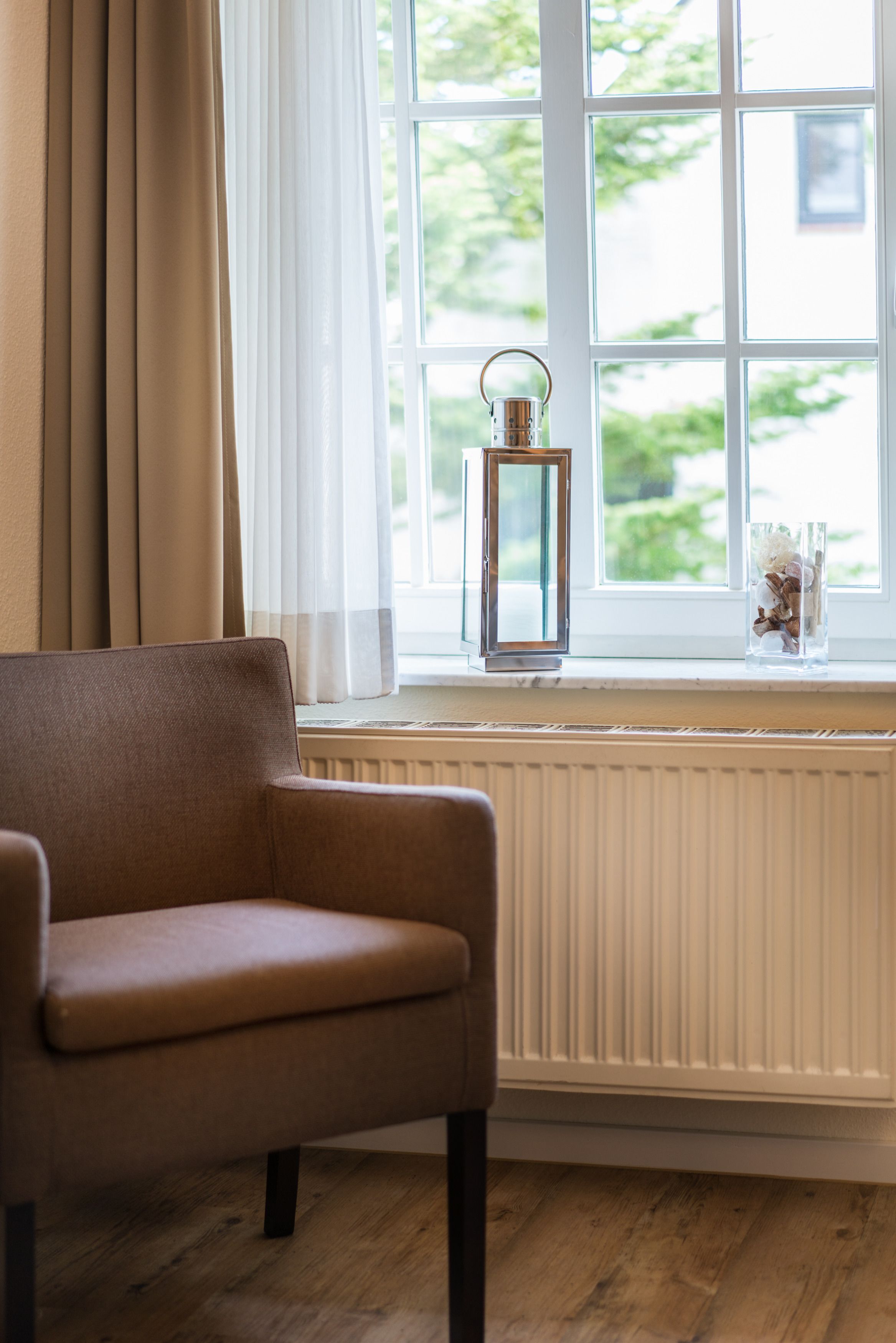 Et værelse med et vindue, en stol og en radiator.