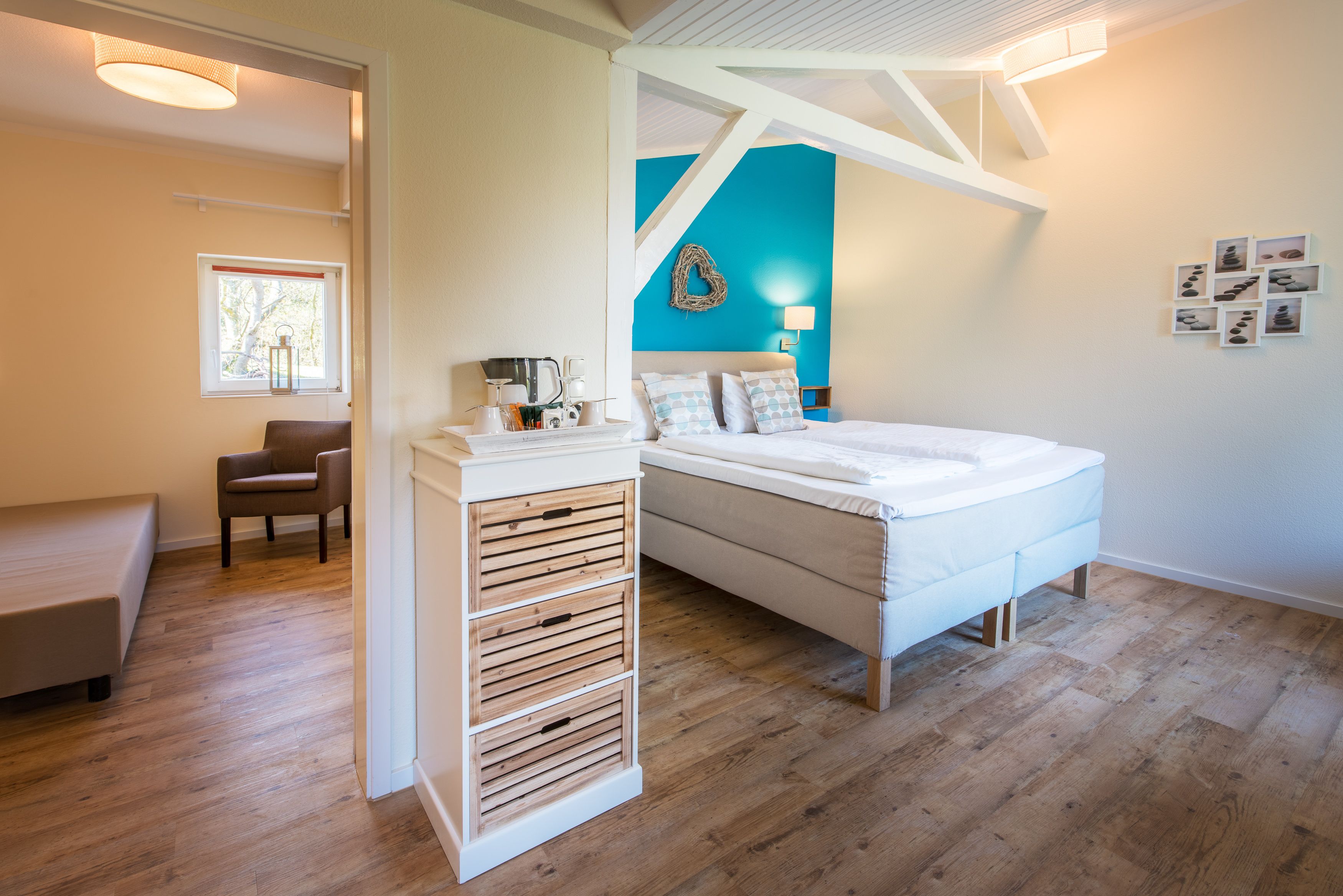 A modern bedroom with a bed, bedside table, chair, and a window.