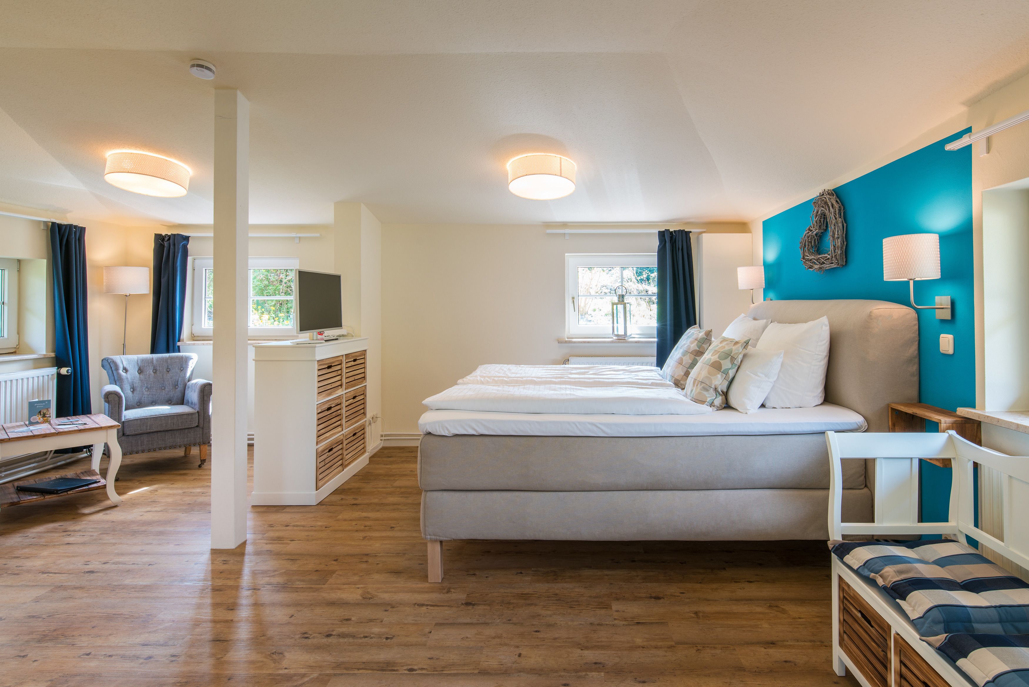 Ein Schlafzimmer mit einem großen Bett, einem Schreibtisch, einem Stuhl und einem Fernseher.