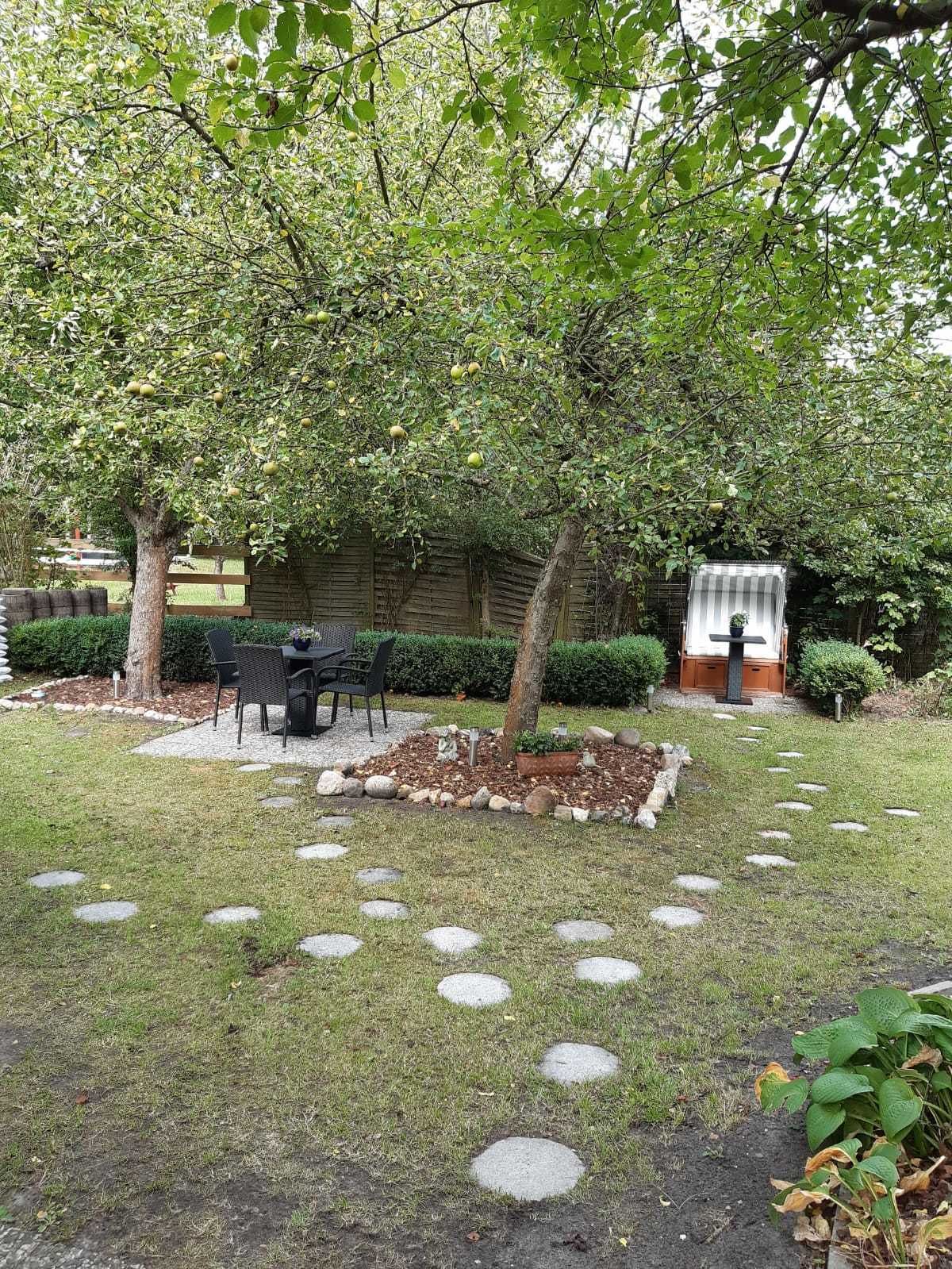 Un jardin agrémenté d’un espace repas, d’une petite cascade et d’un sentier en pierre.