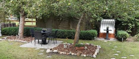 Un jardin agrémenté d’un espace repas, d’une petite cascade et d’un sentier en pierre.