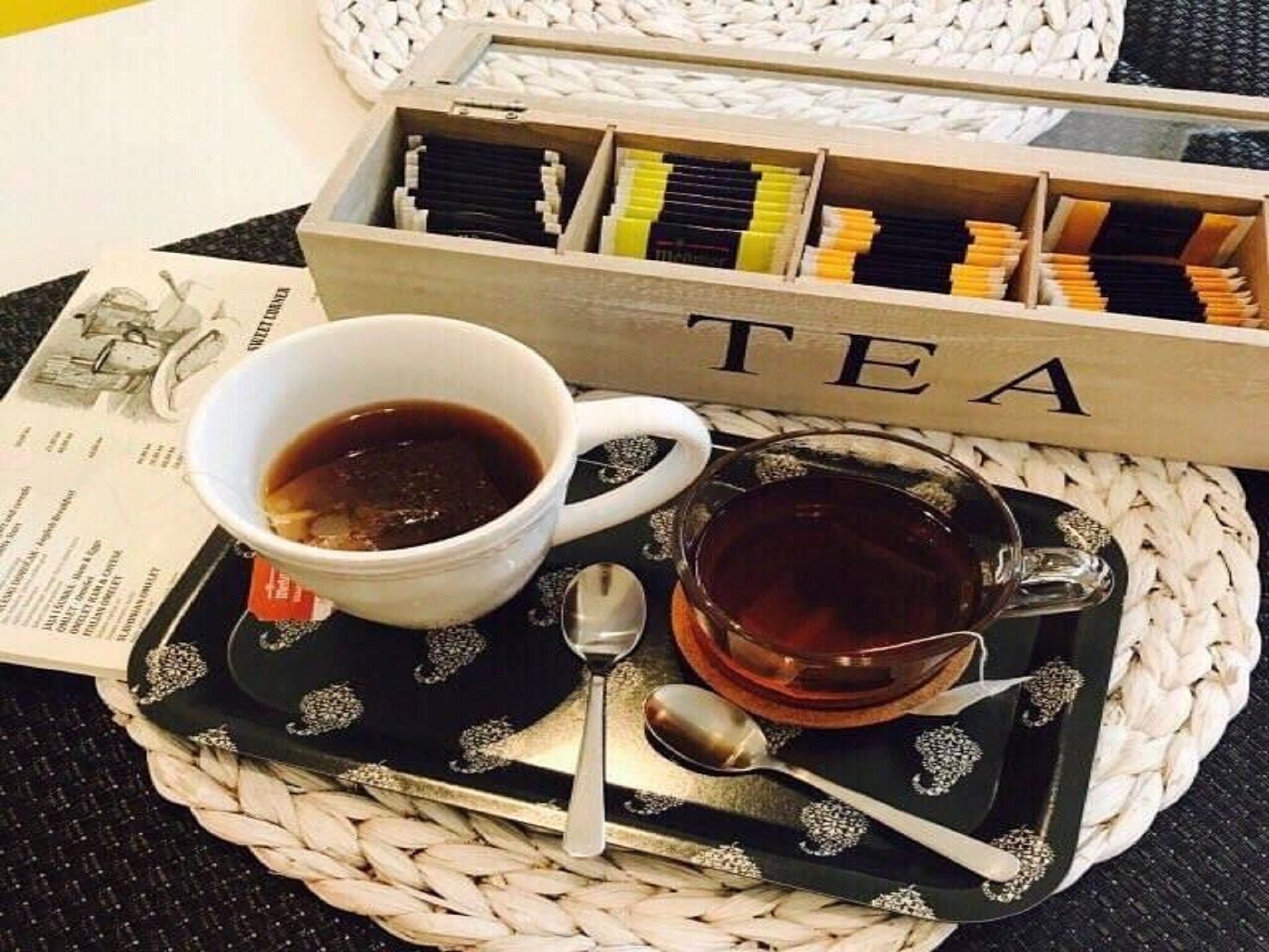 A tray with a cup of tea, a glass of tea, and a box labeled "TEA".