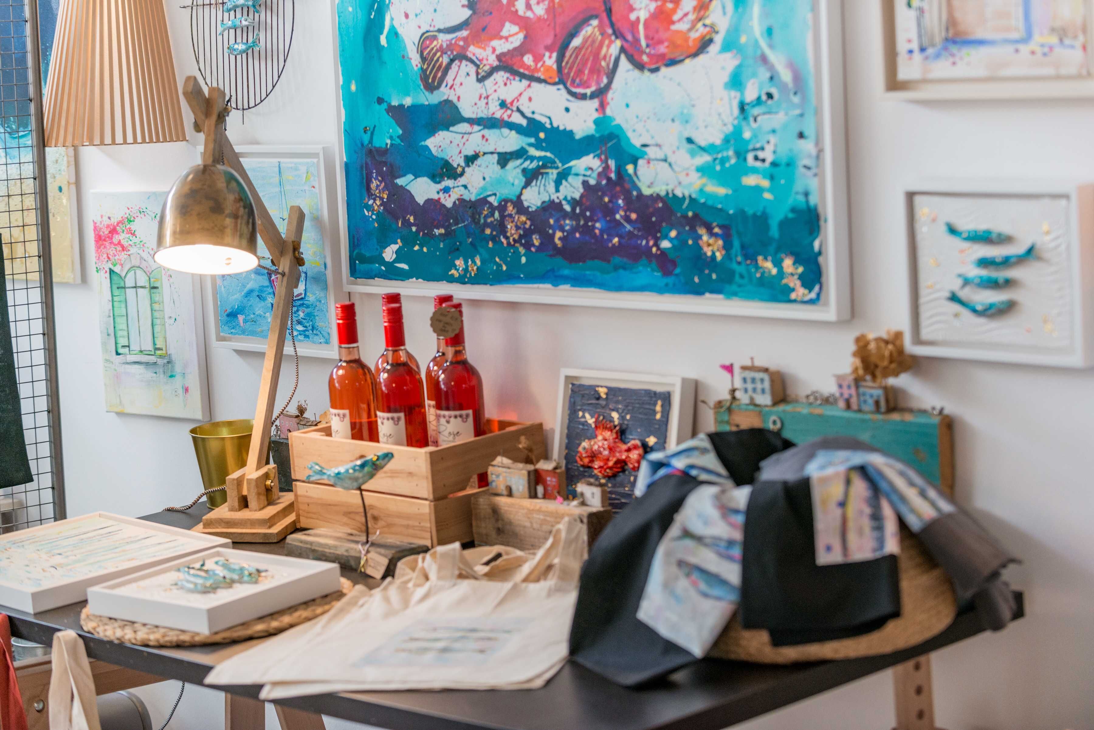 A workspace with art supplies, a lamp, and a painting on the wall.