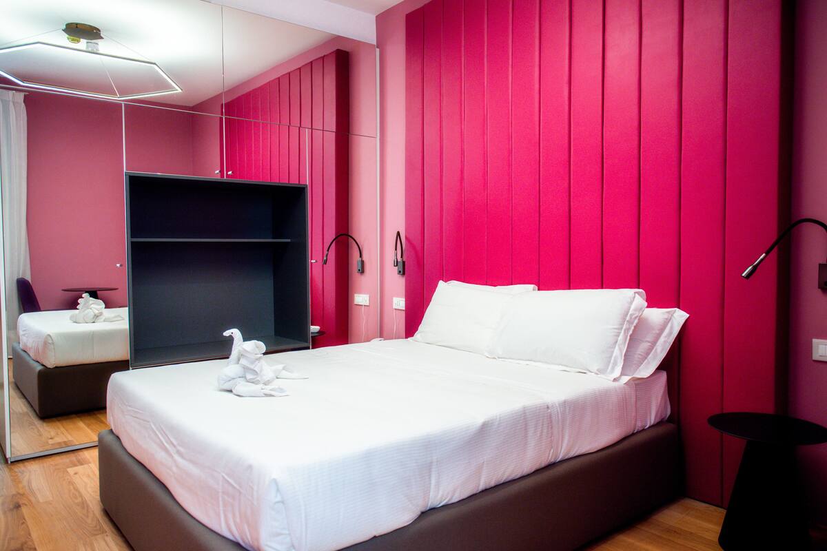 Ein modernes Hotelzimmer mit einem großen Bett, einem Schrank und einem Spiegel.