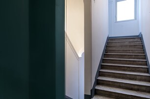 A staircase with wooden steps and a white wall.