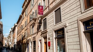 Une rue pavée bordée de bâtiments historiques, dont un magasin dont la devanture, avec une enseigne, indique qu’il s’agit d’un magasin Polo Ralph Lauren.
