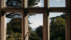 A window with a view of a garden and trees. - Hotel Meudon (Falmouth)