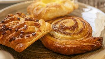 A plate with three pastries, including a cinnamon roll and a Danish.