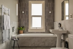 Habitación Deluxe doble | Baño | Cabezal de ducha tipo lluvia y artículos de higiene personal de diseño