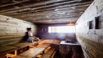 Una sauna de madera con bancos y ducha de vapor.