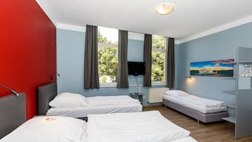 Une chambre d’hôtel avec deux lits, une télévision, un tableau et une fenêtre avec des rideaux.