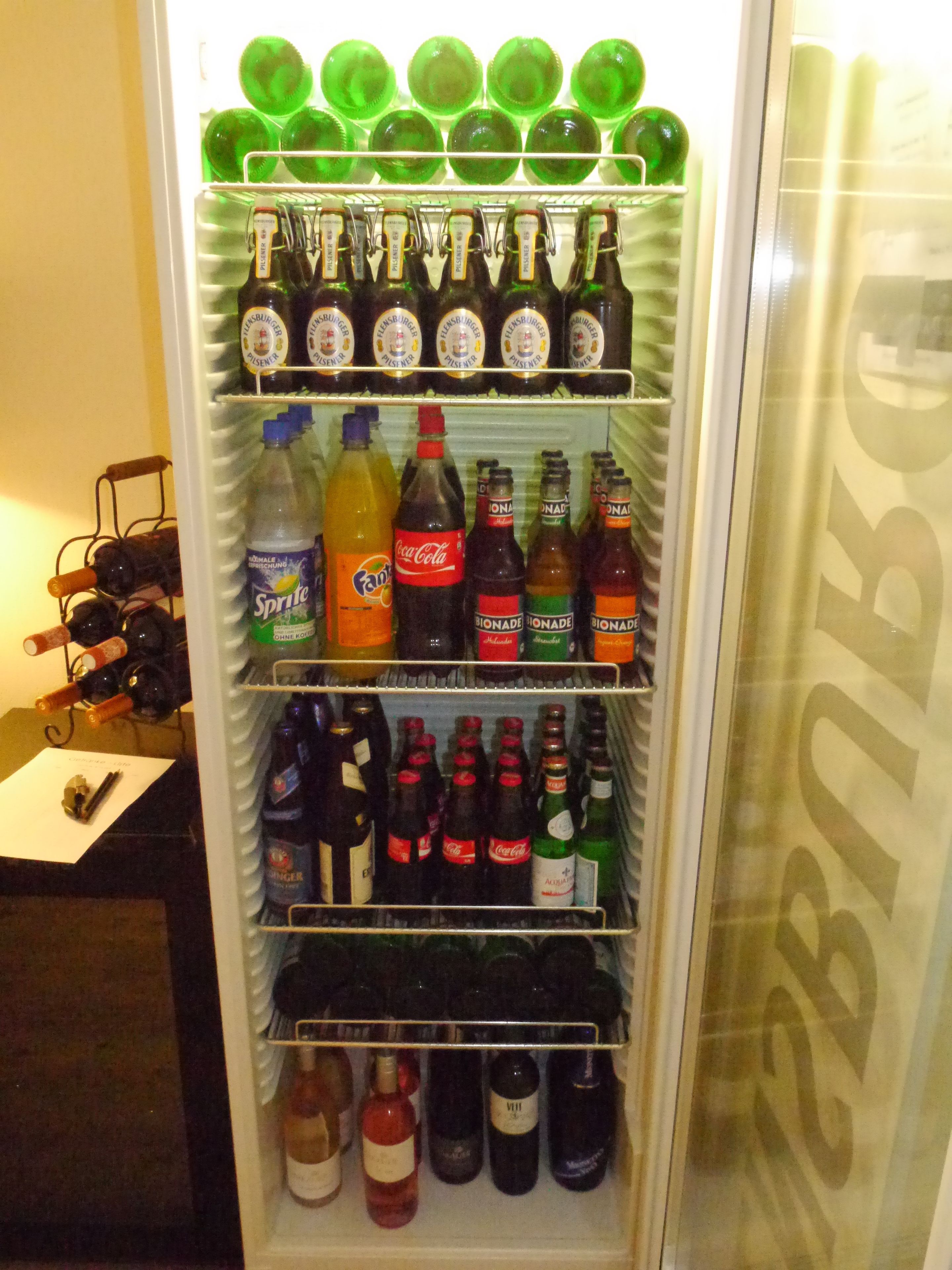 A beverage vending machine stocked with various drinks including sodas, juices, and alcoholic beverages.