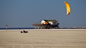 A beach house on stilts with a clear view of the ocean.