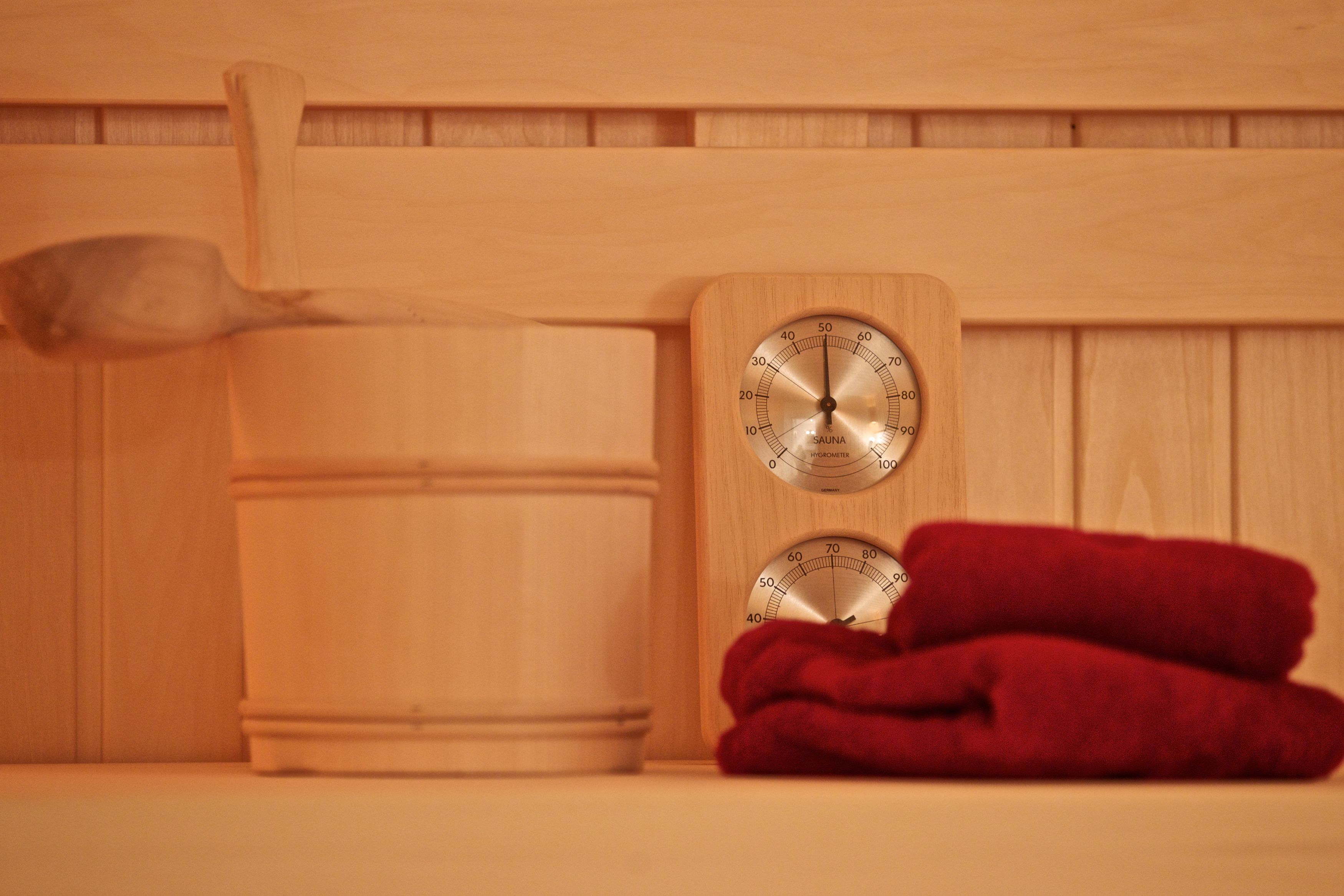 A wooden sauna with a thermometer and a wooden ladle.