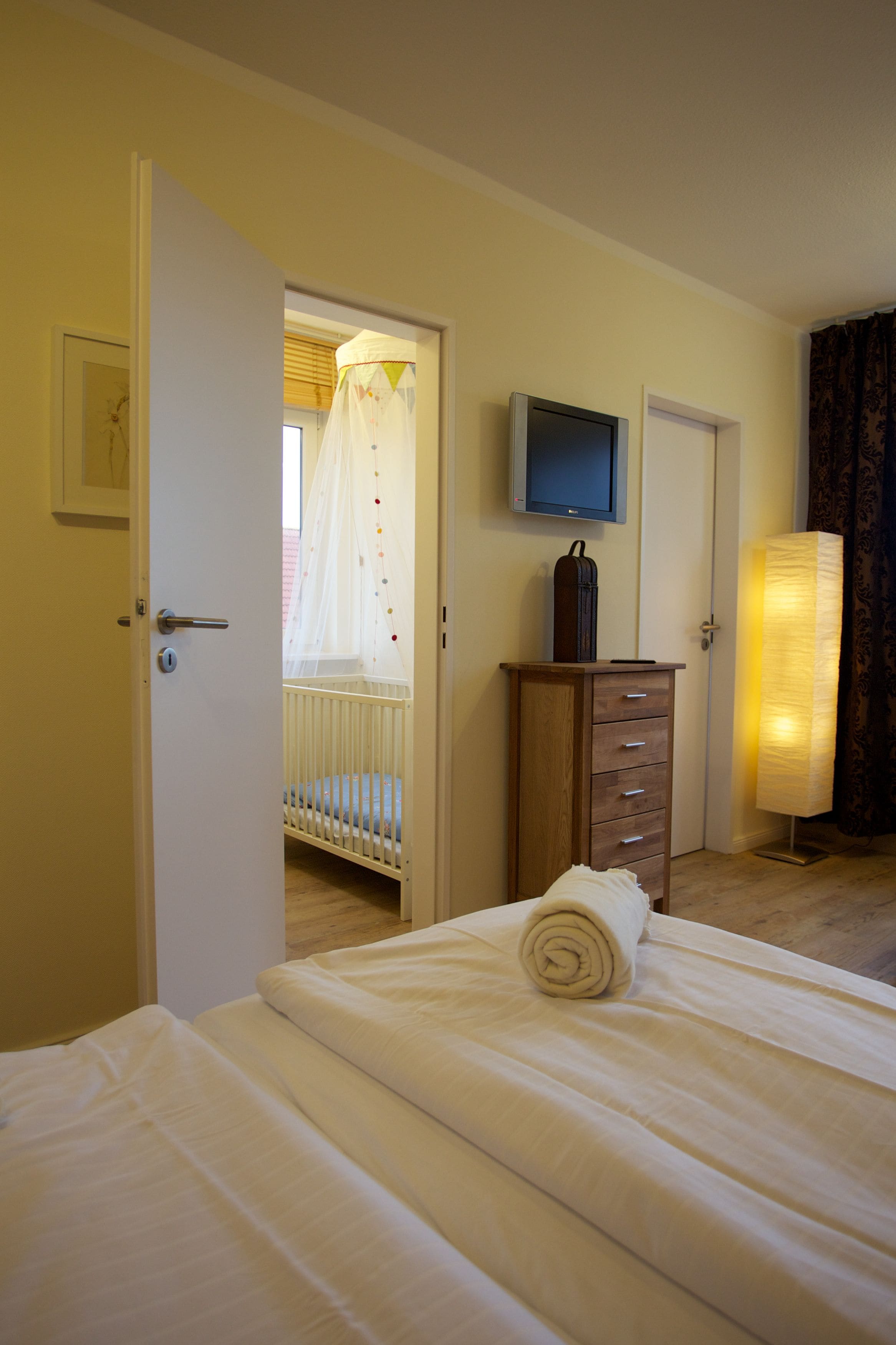 Une chambre d’hôtel équipée d’un lit, d’une télévision, d’une armoire et d’une lampe de chevet.