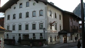 A white building with multiple windows and a sign that reads "Café - Restaurant". - Hotel Bernhard am See (Walchsee)