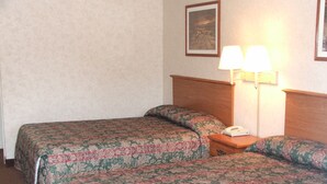 A hotel room with two beds, each with floral-patterned bedding, a nightstand with a lamp, and a telephone. - Deerfield Inn & Suites (Greenbrier)