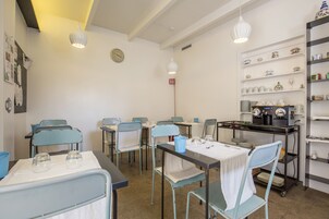 A dining area with tables, chairs, and a coffee station.