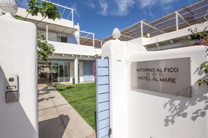 A white building with a sign reading "INTORNO AL FICO HOTEL AL MARE".