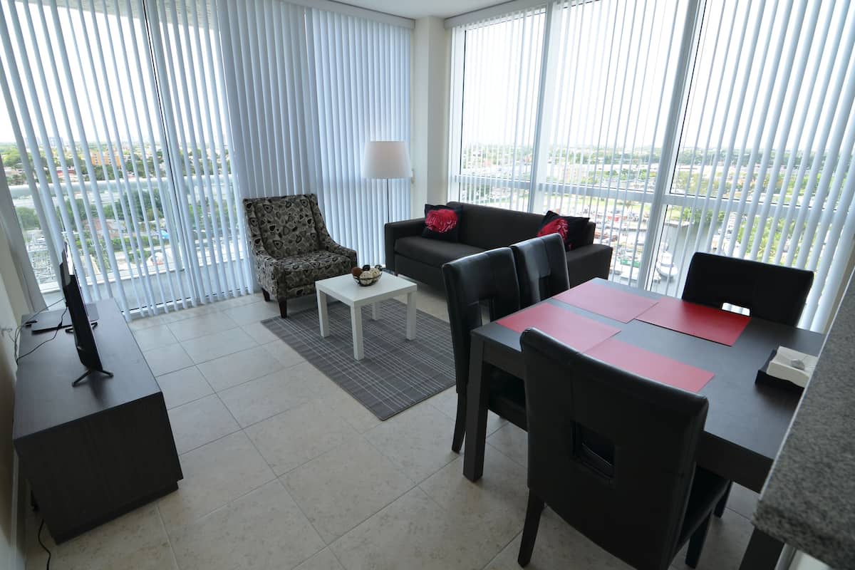 Una sala de estar moderna con un sofá, sillones, una mesa de centro y una mesa de comedor.