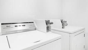 A white heavy-duty commercial washer with a control panel displaying various settings. - FairBridge Inn - Coeur d'Alene (Coeur d'Alene)