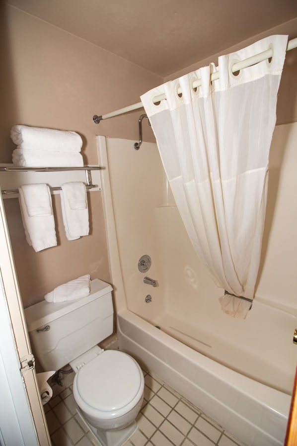 A bathroom with a toilet, a bathtub, and a shower curtain.