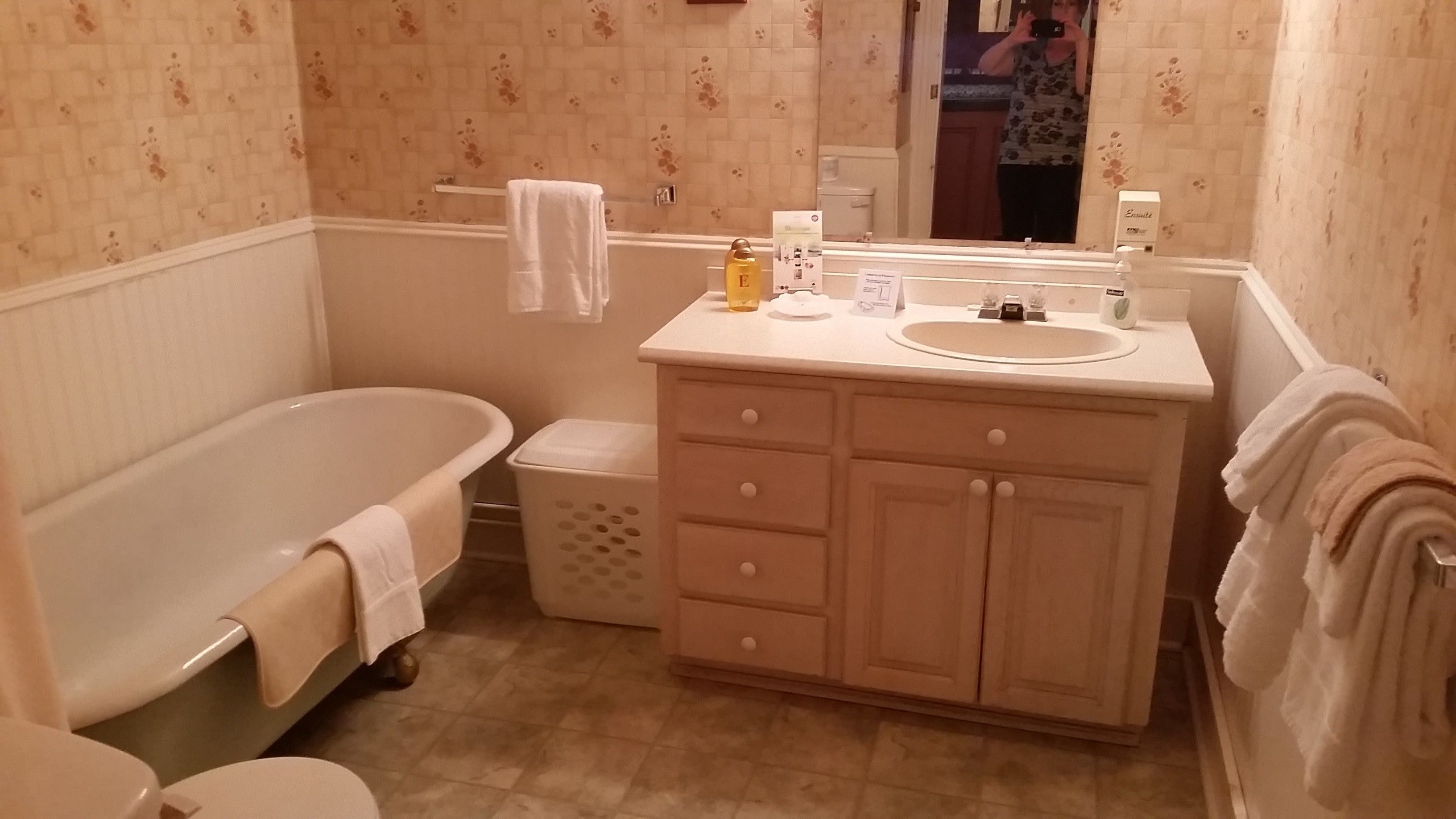 A bathroom with a bathtub, a sink, and a vanity with drawers.
