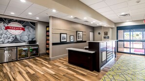 A modern reception area with a counter, framed pictures, and a 'Treats' sign.