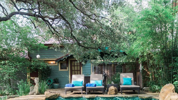 A pool area with lounge chairs and a wooden deck. - Park Lane Guest House (Austin)
