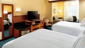 A hotel room with two beds, a desk with a television, a chair, a small table, and a mirror. - Fairfield by Marriott Inn & Suites Wheeling at The Highlands (Triadelphia)