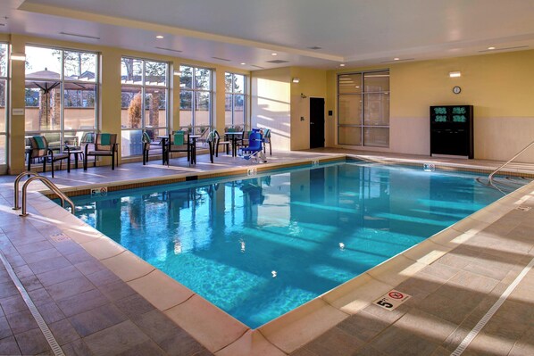An indoor swimming pool with clear water, surrounded by sunlit seating areas and large windows. - Courtyard by Marriott Nashville Mount Juliet (Mount Juliet)