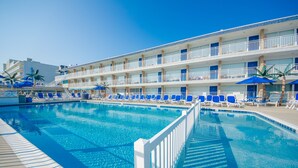 A hotel with a swimming pool, multiple balconies, and sun loungers. - Tangiers Motel (Wildwood Crest)