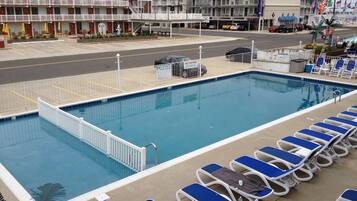A pool area with lounge chairs and a sign indicating no visitors.