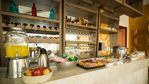A buffet setup with various food items, a fruit bowl, and a beverage dispenser. - Hotel Parque Del Sol (Montería)