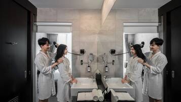 A modern bathroom with two sinks, a large mirror, and a towel rack.