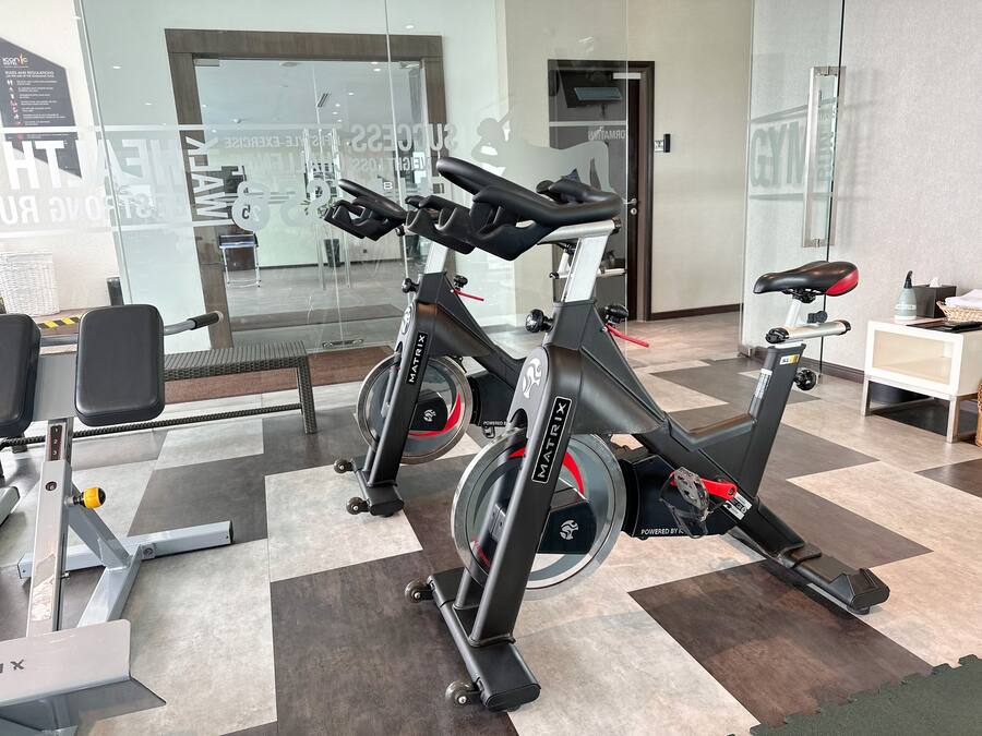 Un gimnasio con bicicletas estáticas y un banco para pesas.