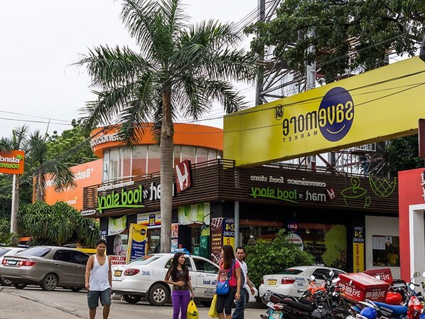 Vista de la calle con varias tiendas, incluyendo una tienda 'Sambong' con un letrero amarillo.