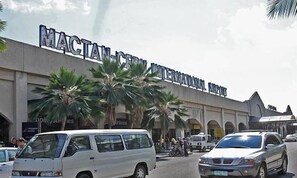 A building with a sign reading "MACTAN INTERNATIONAL AIRPORT". - The Stopover Hostel Mactan (Lapu-Lapu)