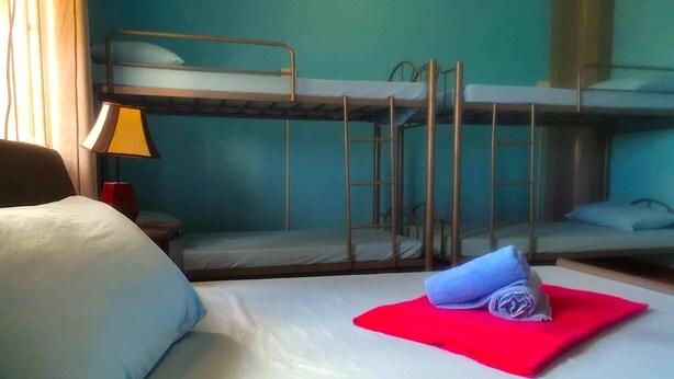 A hotel room with bunk beds, a desk, and a lamp. - The Stopover Hostel Mactan (Lapu-Lapu)