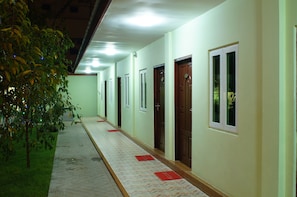 A hallway with doors, windows, and a tiled floor.