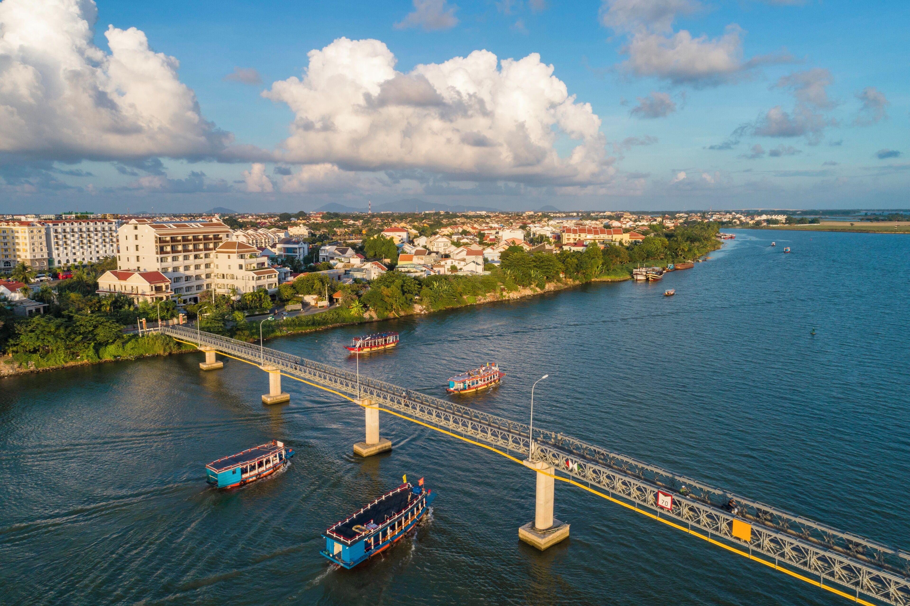 A river with boats, a bridge, and buildings along the riverbank.