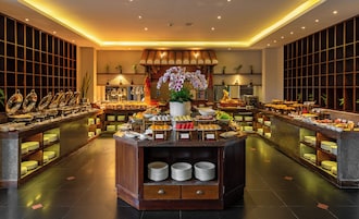 A buffet with various food items, a central floral arrangement, and a tiled floor.
