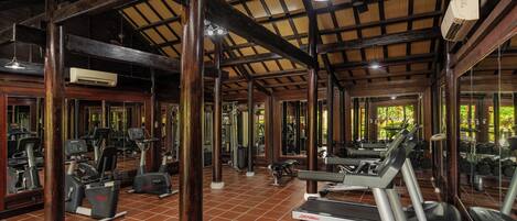 A gym with treadmills, exercise bikes, and weight machines.